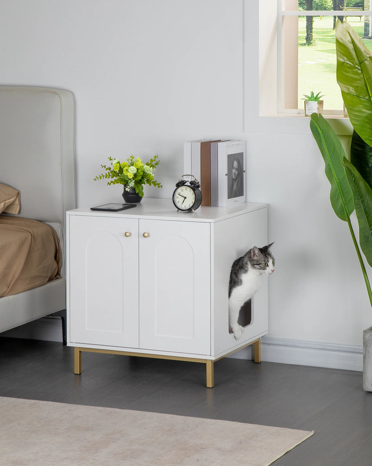 Meuble cache-litière utilisé comme table de chevet dans une chambre